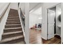Elegant staircase with iron spindles adjacent to a cozy sitting room with hardwood flooring at 4443 Quilter St, Powder Springs, GA 30127