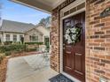 Inviting entryway with a wreath on the brown front door and a view of the cozy front porch at 1045 Brook Knoll Ln # 401, Cumming, GA 30041