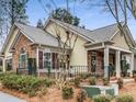 A charming home with brick and siding, featuring a black fence, lush greenery, and well-maintained landscaping at 1045 Brook Knoll Ln # 401, Cumming, GA 30041