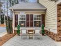Cozy front porch with seating area, featuring two chairs, a small table, and decorative plants at 1045 Brook Knoll Ln # 401, Cumming, GA 30041