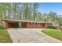 A well-maintained brick home featuring a covered carport and a concrete driveway at 1933 Silvastone Dr, Decatur, GA 30033