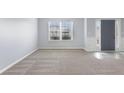 Bright living room featuring neutral carpet, white trim, and a view of the entry door at 2529 Brookgate Way, Ellenwood, GA 30294