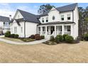 Charming white house with a covered front porch and beautifully landscaped garden at 6635 Canyon Cv, Cumming, GA 30028