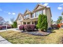 Attractive home exterior with lush green lawn, stone features, and a well-kept landscape at 2195 Well Springs Dr, Buford, GA 30519