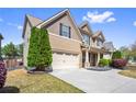 Beautiful home exterior showcases a well-maintained lawn, two-car garage, and complementary landscaping at 2195 Well Springs Dr, Buford, GA 30519