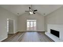 Well-lit living room with a large window, ceiling fan, hardwood floors, and a cozy fireplace at 3245 Country Walk Dr, Powder Springs, GA 30127