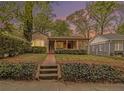 Charming single-story home featuring a brick walkway, red door, and lush landscaping at twilight at 650 Somerset Ne Ter, Atlanta, GA 30306