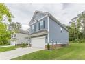 Side view of the home showcasing the blue siding, attached garage, and green lawn, with neighboring houses visible at 9061 Jim Purcell Dr, Covington, GA 30014