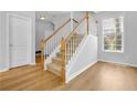 Bright entryway with a staircase featuring wooden railings and neutral carpeting, complemented by modern flooring at 1080 Treymont Ln, Lawrenceville, GA 30045
