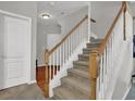 Carpeted staircase with white railings, wood trim, and a view of the front entryway at 1080 Treymont Ln, Lawrenceville, GA 30045