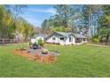 Expansive backyard featuring a dining set, fire pit, and lush green space, perfect for entertaining at 2151 Blaylock Dr, Marietta, GA 30062