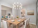 Bright dining room featuring modern chandelier and adjacent living room and kitchen views at 2544 Peyton Woods Sw Trl, Atlanta, GA 30311