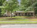 Traditional brick home with arched porch features and a lush, tree-filled front yard at 2544 Peyton Woods Sw Trl, Atlanta, GA 30311