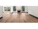 Expansive living area featuring hardwood floors and a fireplace, illuminated by natural light from large arched windows at 1 Mooregate Sq, Atlanta, GA 30327
