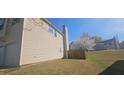 A spacious backyard with a privacy fence and blooming tree sits next to a two-story home with a garage and vinyl siding at 116 Ventura Trl, Stockbridge, GA 30281