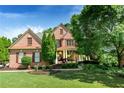 Charming brick home boasts mature landscaping, shuttered windows and covered front porch at 5347 Harbury Cv, Suwanee, GA 30024