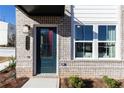Inviting front entrance with a stylish door, modern address plaque, and brick facade with nice plants at 335 Skylar Se Way, Atlanta, GA 30315