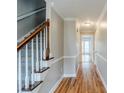 Bright hallway with hardwood floors, neutral paint, and stairway with modern white spindles at 5611 Manassas Run, Stone Mountain, GA 30087