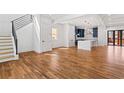Spacious open-concept living area with hardwood floors, staircase, and modern kitchen in the background at 387 S Howard Se St, Atlanta, GA 30317