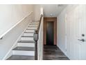Hallway with stairs, hardwood floors, white walls, and a door with wood slats leading to another room at 2164 Mill Garden Run, Buford, GA 30519