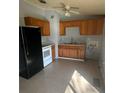 Functional kitchen with wooden cabinets, black appliances, and tile flooring ready for customization at 407 Hilltop Dr, Forest Park, GA 30297