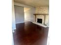 Spacious living room featuring hardwood floors and a unique stone fireplace at 407 Hilltop Dr, Forest Park, GA 30297