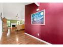 Inviting foyer showcasing hardwood floors, a bold red accent wall, and seamless access to the living area at 1395 Brisbane Dr, Dacula, GA 30019