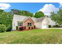 Side view of a well-maintained home featuring brick and siding, a neat lawn, and an attached garage at 1395 Brisbane Dr, Dacula, GA 30019