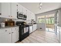Cozy kitchen featuring white cabinets, subway tile backsplash, granite countertops, and backyard access at 1755 Fairburn Sw Rd, Atlanta, GA 30331