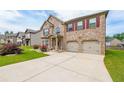 Inviting brick home with a spacious driveway, attached two-car garage, and lovely landscaping at 8097 White Oak Loop, Lithonia, GA 30038