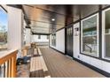 Wide, covered porch with stained wood deck, stone pillars, black door, and white trim at 1569 Montreat Sw Ave, Atlanta, GA 30311