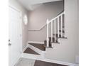 Bright foyer with staircase featuring white railings and wood steps, leading to the upper level at 4502 Lake Park Dr, Acworth, GA 30101