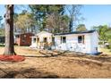 View of a cozy single-story home with a classic white exterior, front porch, and landscaping at 661 Inglewood Se Dr, Smyrna, GA 30080
