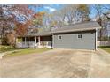Exterior view of gray home with a porch, red front door, and a spacious driveway on a sunny day at 1354 Litchfield Ct, Snellville, GA 30078