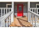 Inviting front porch view with a vibrant red door, decorative glass, and stylish sconces offering curb appeal at 1354 Litchfield Ct, Snellville, GA 30078