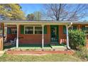 Welcoming brick home featuring a covered front porch, green door, and matching shutters at 1122 Byers Sw Dr, Marietta, GA 30060