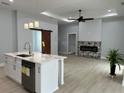 Open-concept living area featuring a fireplace, wood-look flooring, and a view of the kitchen island at 135 Yancey Rd, Covington, GA 30014