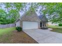 Side view of home with two-car garage and green lawn at 223 Gilliam Ct, Locust Grove, GA 30248