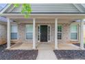 Home featuring columned front porch with attractive landscaping at 223 Gilliam Ct, Locust Grove, GA 30248