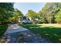 Long driveway leading up to a home with a detached garage, lush greenery, and mature trees at 5440 Shady Grove Rd, Cumming, GA 30041