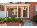 Inviting brick home featuring a covered front porch with classic white columns and trim at 6065 Nw Gentlewind Court Nw Ct, Powder Springs, GA 30127