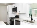 Modern kitchen features white cabinets, stainless steel appliances and granite countertops at 1570 Childress Sw Dr, Atlanta, GA 30311