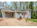 Side view of the gray split level home with a carport and walkway leading to the red front door at 3436 Misty Valley Rd, Decatur, GA 30032