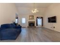 Bright living room with a stone fireplace, high ceilings, ceiling fan, and neutral walls at 10 Flowers Dr, Covington, GA 30014