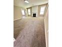 Open living room featuring plush carpeting, a cozy fireplace, and ample natural light at 4244 Old House Dr, Conley, GA 30288