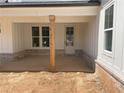 View of the covered porch featuring brick accents, wooden columns, and a classic white door at 1698 Cunningham Sw Rd, Marietta, GA 30008