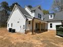 Charming two-story home with white siding, a gray roof, and a welcoming covered porch with wooden columns at 1698 Cunningham Sw Rd, Marietta, GA 30008