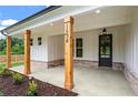 Inviting front porch with stained wood columns and craftsman-style door at 1698 Cunningham Sw Rd, Marietta, GA 30008