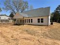 Rear exterior of home with white siding, a gray roof, and a covered patio area perfect for entertaining at 1698 Cunningham Sw Rd, Marietta, GA 30008
