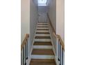 Staircase with white risers, wood treads and handrail plus black metal balusters at 1698 Cunningham Sw Rd, Marietta, GA 30008